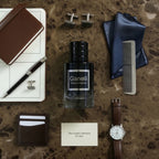 Ganelli No. 6 for Him Aquatic Ocean Eau de Parfum bottle with black cap, surrounded by men's accessories.